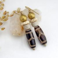 These handmade earrings feature Tibetan agate beads with a brown and tan tribal pattern accented with African beige glass and carved bone beads topped off with gold brass beads. Unique and fun to wear - they'll add a boho tribal flair to your wardrobe. Handmade in the USA by Desert Earth Jewelry.