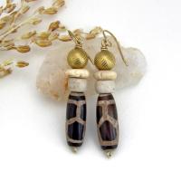 These handmade earrings feature Tibetan agate beads with a brown and tan tribal pattern accented with African beige glass and carved bone beads topped off with gold brass beads. Unique and fun to wear - they'll add a boho tribal flair to your wardrobe. Handmade in the USA by Desert Earth Jewelry.