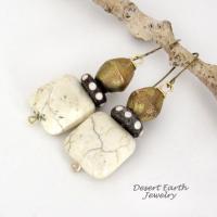 These handcrafted earrings feature natural creamy beige magnesite stones accented with African brass and batik bone beads with a dotted pattern.