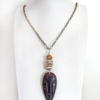 This handcrafted necklace features a carved wood African mask accented with a giraffe print etched agate, golden tiger's eye gemstones and an African carved bone bead. Unique and striking, it'll make a great gift for someone that loves one-of-a-kind ethnic inspired jewelry! It comes on an 18” antiqued brass chain with sturdy hook & eye closure.  Makes a great gift for a man or women that loves African art!