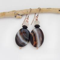 These handcrafted earrings feature natural banded agate gemstones accented with black onyx and white crystal beads. The stones have a unique natural pattern with swirls of orange, black and white. They'll make a great gift for anyone that appreciates the beauty of natural gemstones. Great Halloween and fall colors. Unique and one-of-a-kind, they'll make a great gift for a natural gemstone lover.