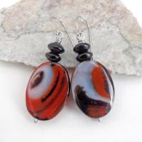 These handcrafted earrings feature natural banded agate gemstones accented with black onyx beads. The stones have a unique natural pattern with swirls of orange, black and white. They'll make a great gift for anyone that appreciates the beauty of natural gemstones. Unique and one of a kind, they'll make a great gift for women that love natural stones.