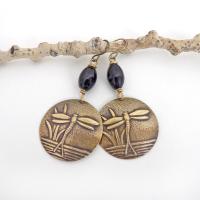 These handmade earrings feature gold brass charms with an embossed nature pattern of dragonflies and leaves. They are accented with black beads and dangle from antiqued brass ear wires. Lightweight and comfortable to wear, they'll make a great gift for a nature lover.