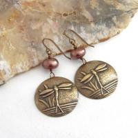 These handmade earrings feature antiqued gold brass charms with an embossed nature pattern of dragonflies and leaves. They are accented with bronze freshwater pearls and dangle from antiqued brass ear wires. Lightweight and comfortable to wear, they'll make a great gift for a nature lover.