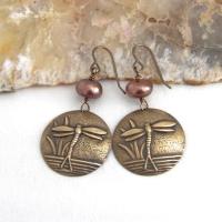 These handmade earrings feature antiqued gold brass charms with an embossed nature pattern of dragonflies and leaves. They are accented with bronze freshwater pearls and dangle from antiqued brass ear wires. Lightweight and comfortable to wear, they'll make a great gift for a nature lover.