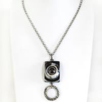 This handmade necklace features a natural eye agate stone accented with a hammered silver pewter circle. When cut at the right angle, this type of stone reveals a series of concentric rings that resembles the human eye. The stone in this piece has a bold matrix of black and white bands with a black circular center. It will make a great gift for a natural stone lover. 