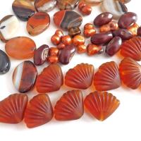 Mixed bead lot for jewelry making / beading / craft supply.  Lot consists of 14 pieces of oval-shaped banded agate beads (black orange white tones with various matrix patterns). Measures approximately 7/8" to 1" in length and 3/4" in width - drilled top to bottom. 12 pieces of burnt orange seashell shaped beads. Measures approximately 1" at widest point and 3/4" in length - drilled top to bottom 9 bright orange organically shaped freshwater pearl beads - drilled 8 dark reddish-brown dried bean beads