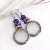 These handcrafted earrings feature silver pewter circle hoops with a hand stamped texture accented with colorful African glass beads and navy blue glass beads. They have an earthy, boho style and are lightweight and comfortable to wear.  MEASUREMENTS: Total length 2" from top of gray silver niobium (hypoallergenic) ear wires and 1” at widest point. The circles were created out of solid lead-free pewter; hand stamped and oxidized; and signed on the back with my initials