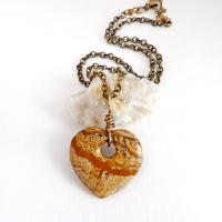 This handcrafted pendant necklace has a simplistic earthy charm. It features a natural picture jasper gemstone carved into a heart shape. It's wrapped in antiqued brass wire and comes on an 18" antiqued brass chain. The stone has a natural pattern with markings of tan, mocha brown and black. Makes a great gift to tell someone "I love you" - or a nice addition to your own jewelry collection.