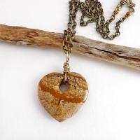 This handcrafted pendant necklace has a simplistic earthy charm. It features a natural picture jasper gemstone carved into a heart shape. It's wrapped in antiqued brass wire and comes on an 18" antiqued brass chain. The stone has a natural pattern with markings of tan, mocha brown and black. Makes a great gift to tell someone "I love you" - or a nice addition to your own jewelry collection.