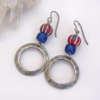 These handcrafted earrings feature silver pewter circle hoops with a hand stamped texture accented with red, white and blue carved clay beads and navy blue glass beads. They have an earthy, boho style and are lightweight and comfortable to wear. Great USA colors for a July 4th celebration. 