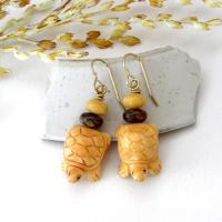 Super cute and fun to wear - these handmade earrings feature yellow jasper stones carved into sweet, little turtles. They are accented with fossilized beige coral and brown bronzite stone beads. They'll make a great gift for a turtle or animal lover. Turtles are powerful symbols of patience, wisdom, longevity and protection across many global cultures. Because of their hard shells and long lifespans, they represent stability and endurance, reminding us to move through life with steady determination.