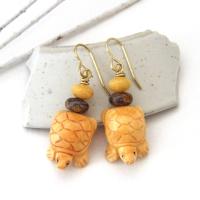 Super cute and fun to wear - these handmade earrings feature yellow jasper stones carved into sweet, little turtles. They are accented with fossilized beige coral and brown bronzite stone beads. They'll make a great gift for a turtle or animal lover. Turtles are powerful symbols of patience, wisdom, longevity and protection across many global cultures. Because of their hard shells and long lifespans, they represent stability and endurance, reminding us to move through life with steady determination.