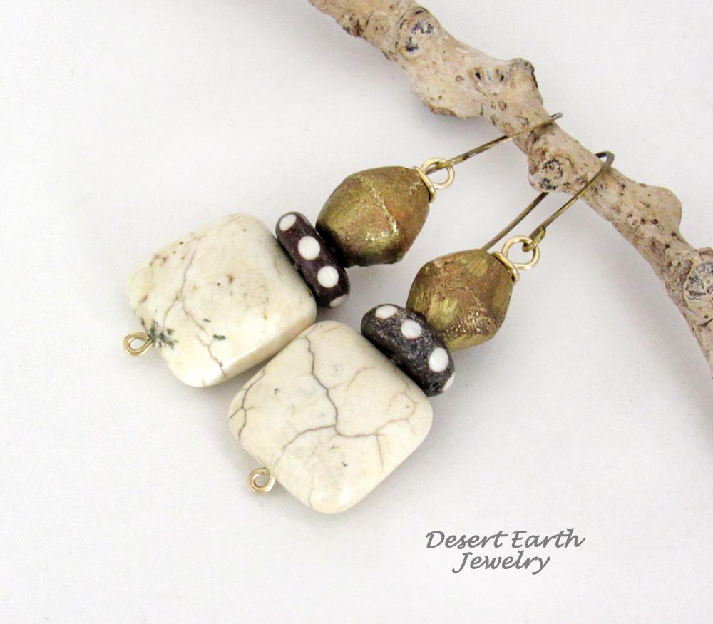 These handcrafted earrings feature natural creamy beige magnesite stones accented with African brass and batik bone beads with a dotted pattern.
