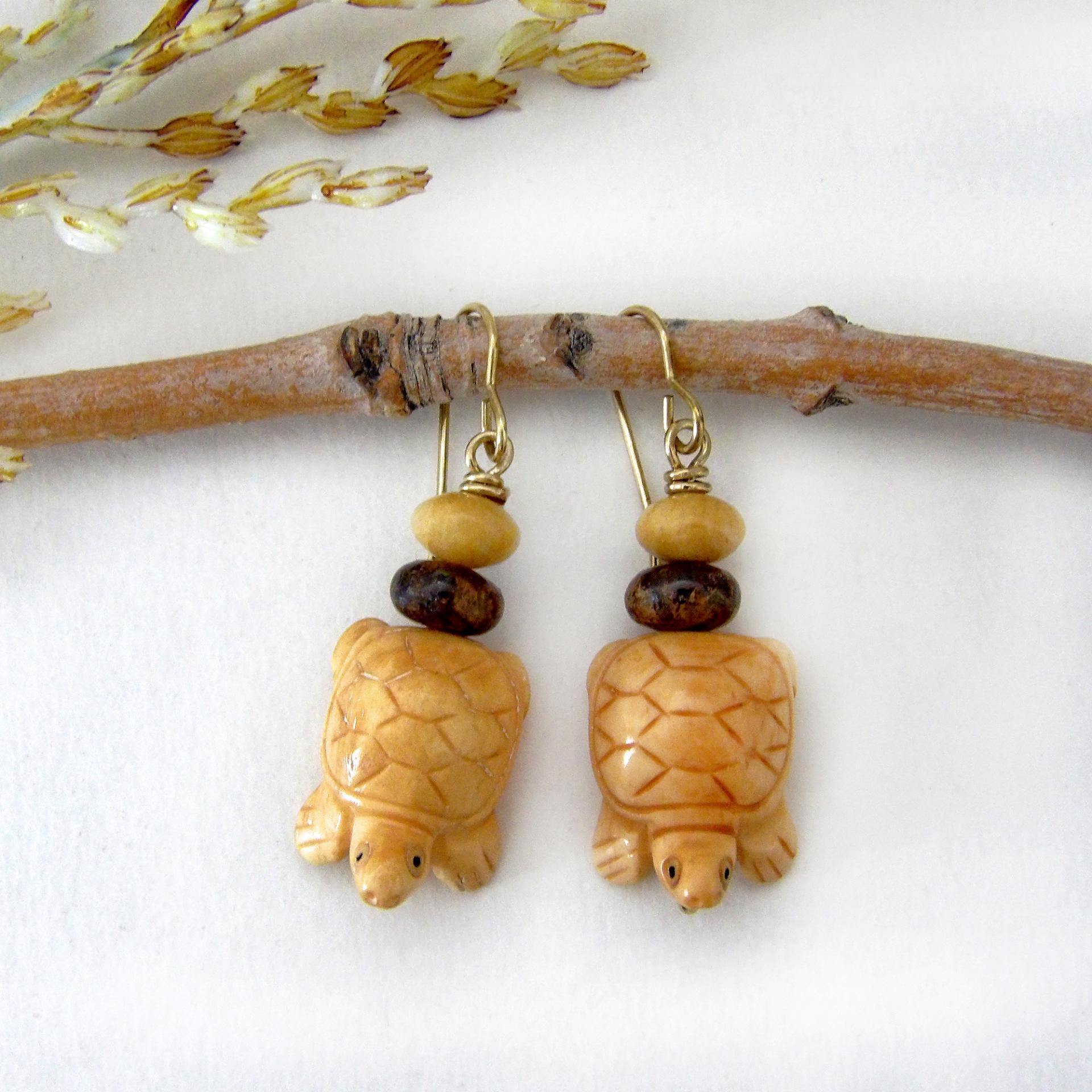 Super cute and fun to wear - these handmade earrings feature yellow jasper stones carved into sweet, little turtles. They are accented with fossilized beige coral and brown bronzite stone beads. They'll make a great gift for a turtle or animal lover. Turtles are powerful symbols of patience, wisdom, longevity and protection across many global cultures. Because of their hard shells and long lifespans, they represent stability and endurance, reminding us to move through life with steady determination.