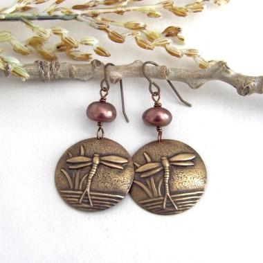 These handmade earrings feature antiqued gold brass charms with an embossed nature pattern of dragonflies and leaves. They are accented with bronze freshwater pearls and dangle from antiqued brass ear wires. Lightweight and comfortable to wear, they'll make a great gift for a nature lover.